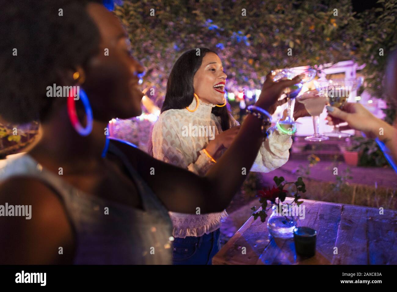 De jeunes femmes amis heureux buvant des cocktails à la fête de l'arrière-cour Banque D'Images