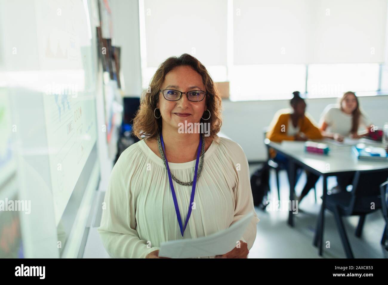 Portrait confiant professeur de lycée féminin à l'écran de projection dans la salle de classe Banque D'Images