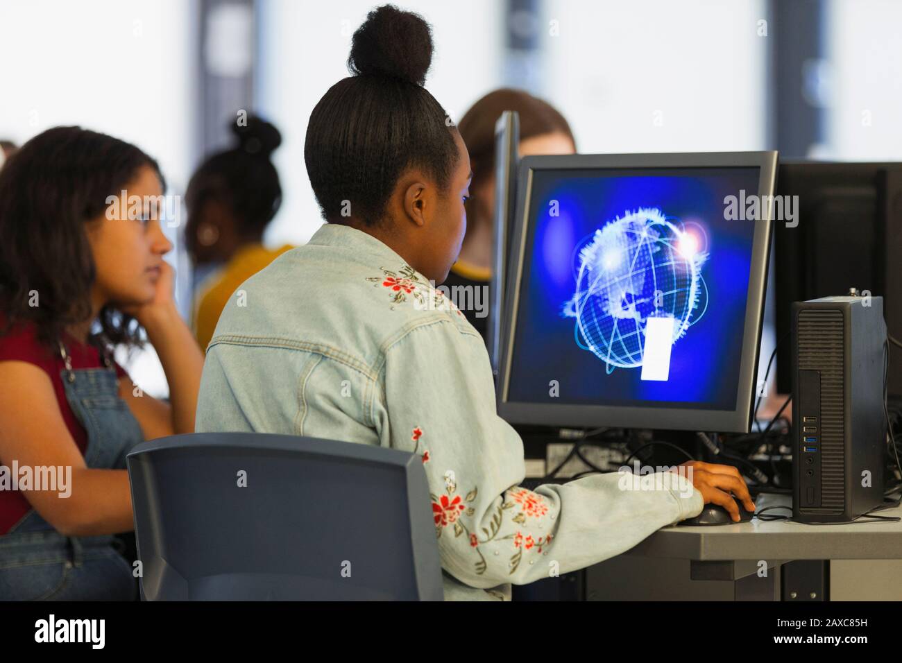 Jeune fille étudiant utilisant l'ordinateur dans le laboratoire d'ordinateur Banque D'Images