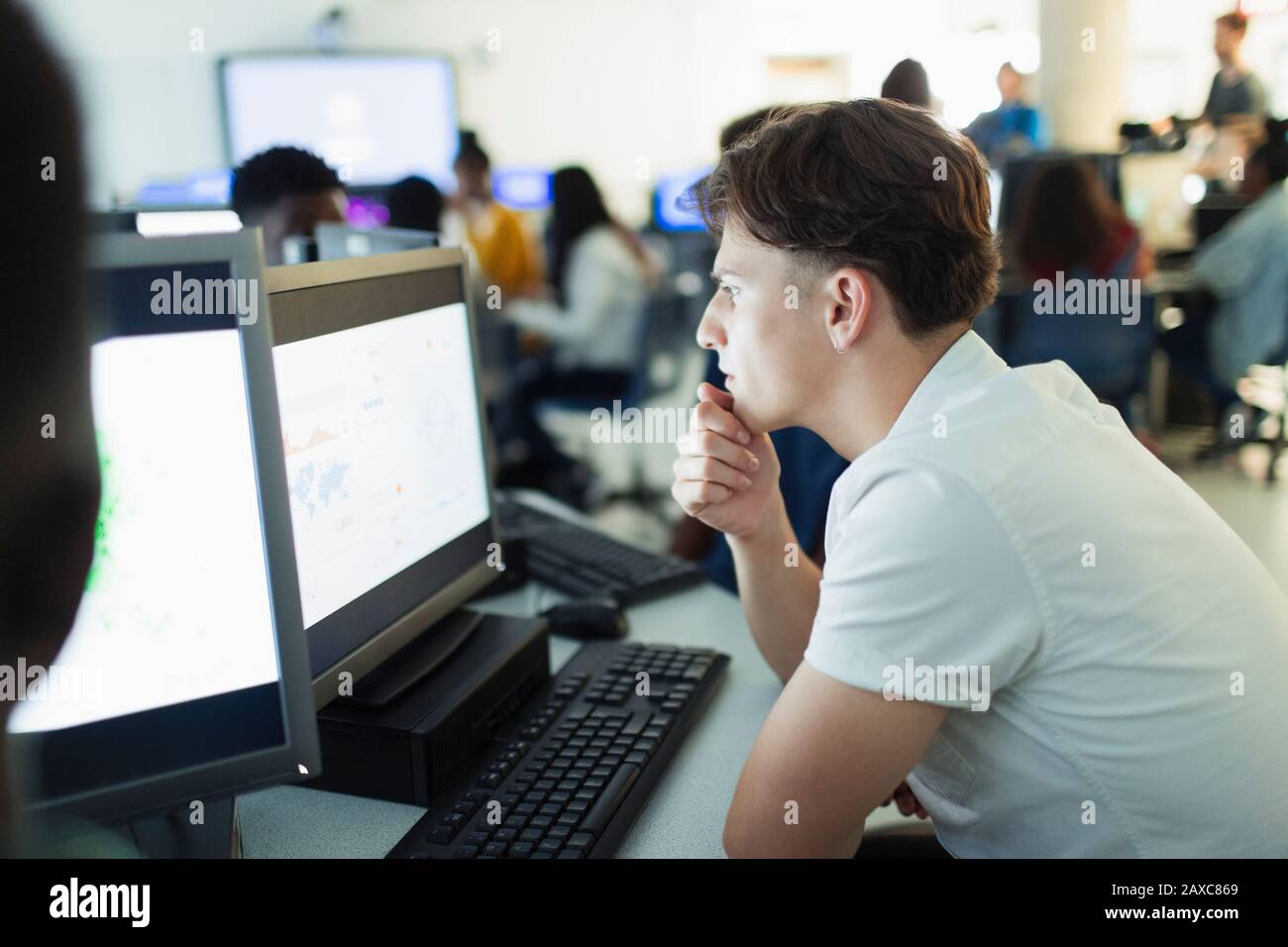 L'accent junior high boy student using computer in computer lab Banque D'Images