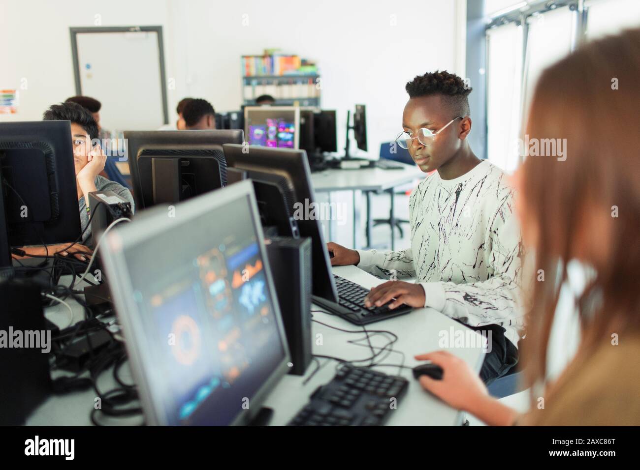 L'accent junior high boy student using computer in computer lab Banque D'Images