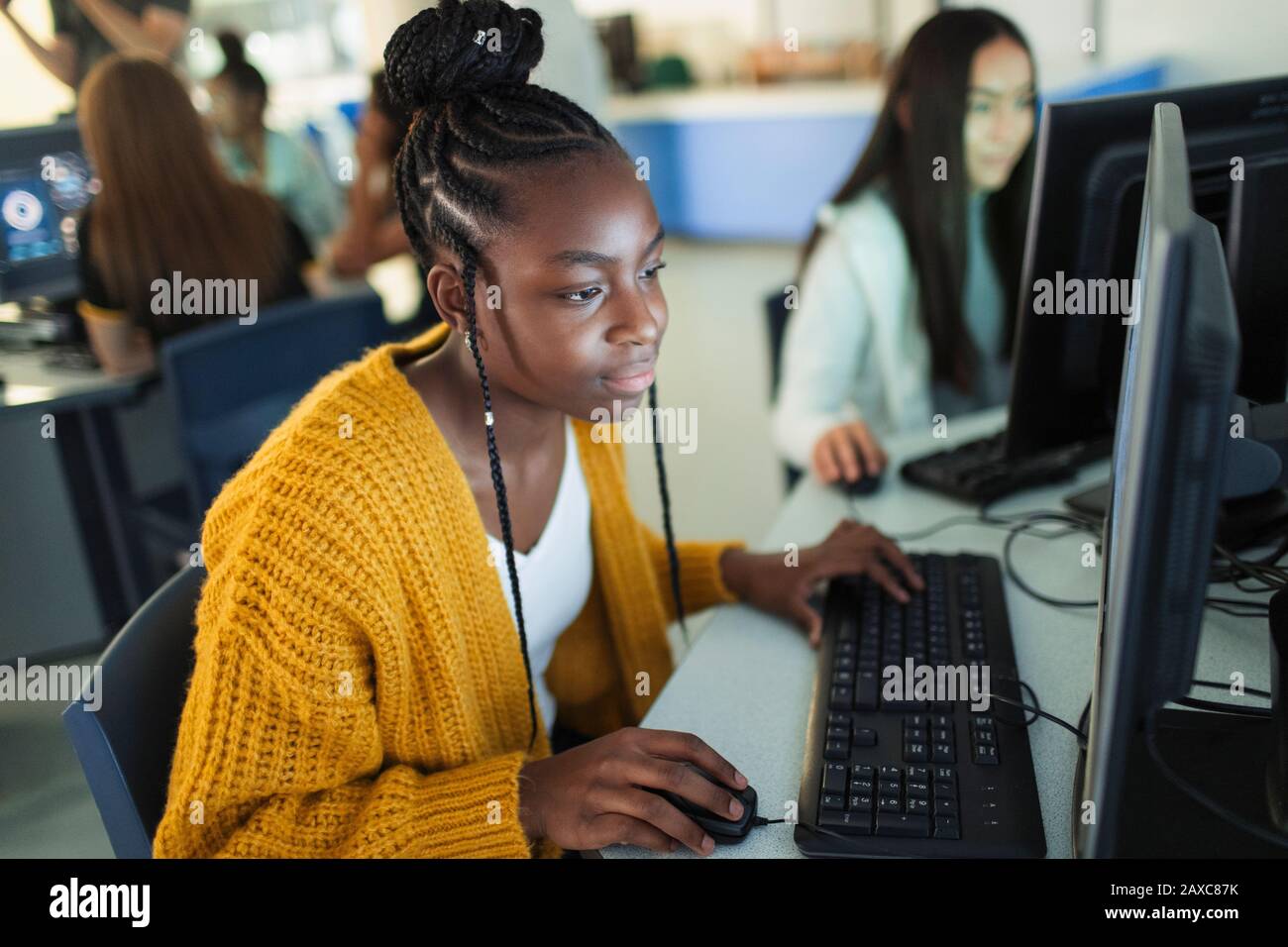Étudiant junior de haute fille focalisé utilisant l'ordinateur dans le laboratoire d'ordinateur Banque D'Images