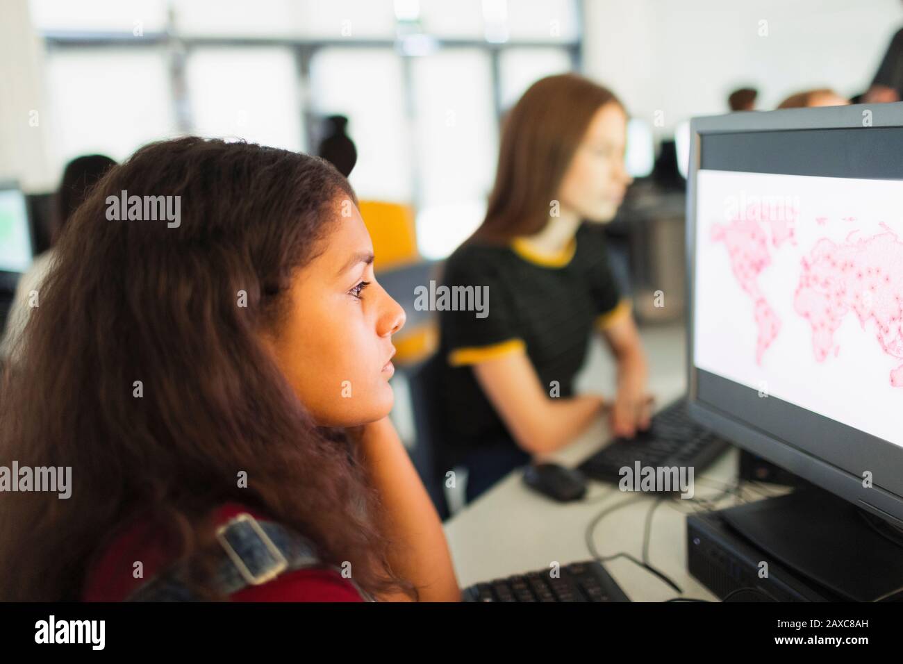 Étudiant junior de haute fille focalisé utilisant l'ordinateur dans le laboratoire d'ordinateur Banque D'Images