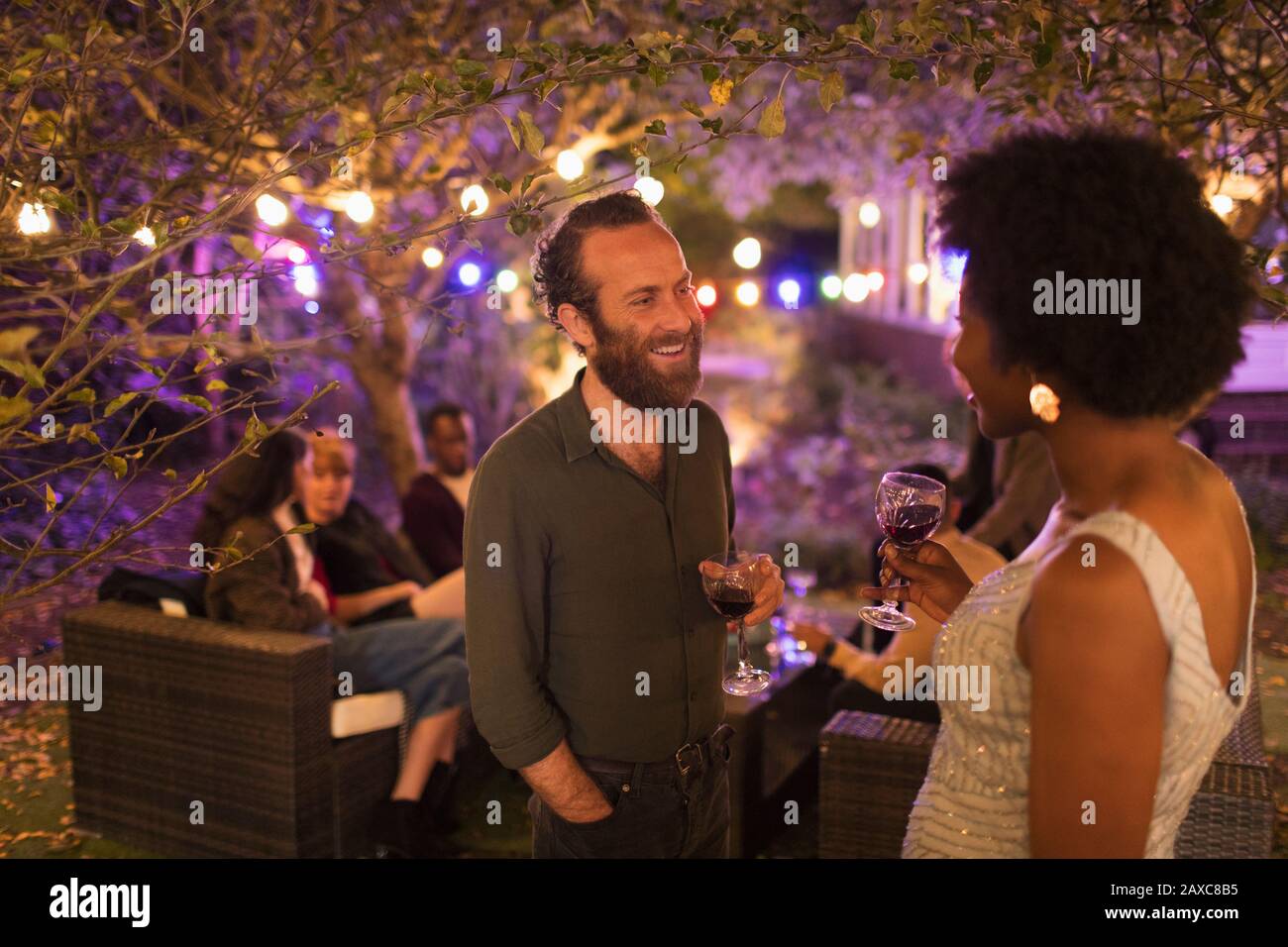 Des amis parlent et boivent à la fête du jardin Banque D'Images