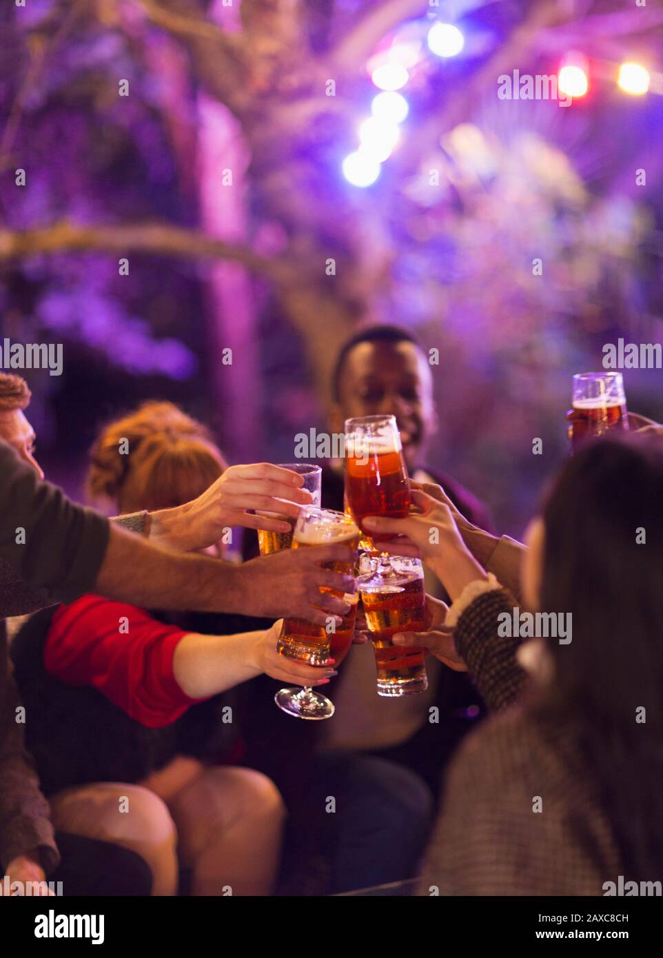 Des amis dégustant des verres à bière à la fête Banque D'Images