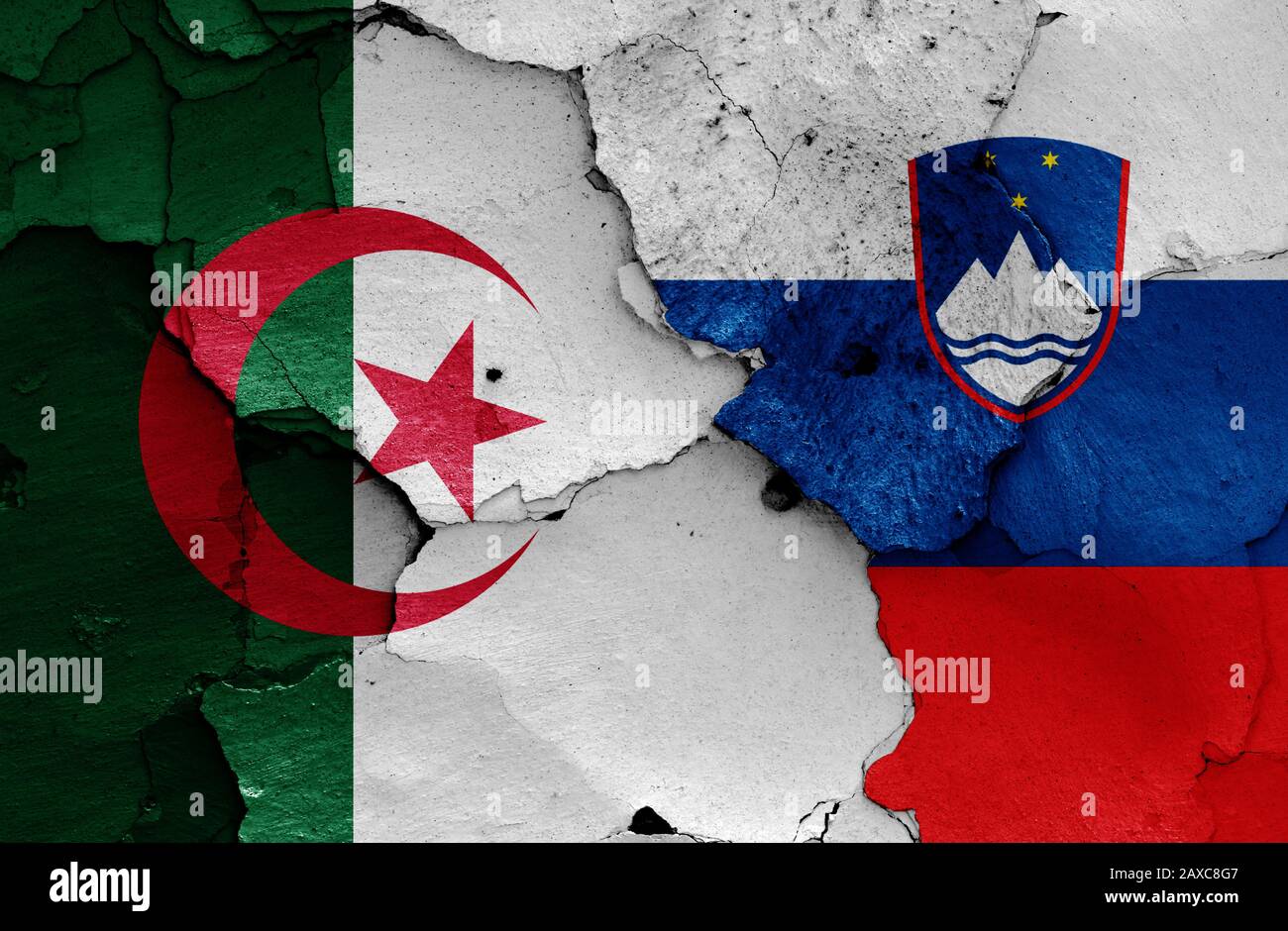 Drapeaux de l'Algérie et de la Slovénie peints sur un mur fissuré Banque D'Images
