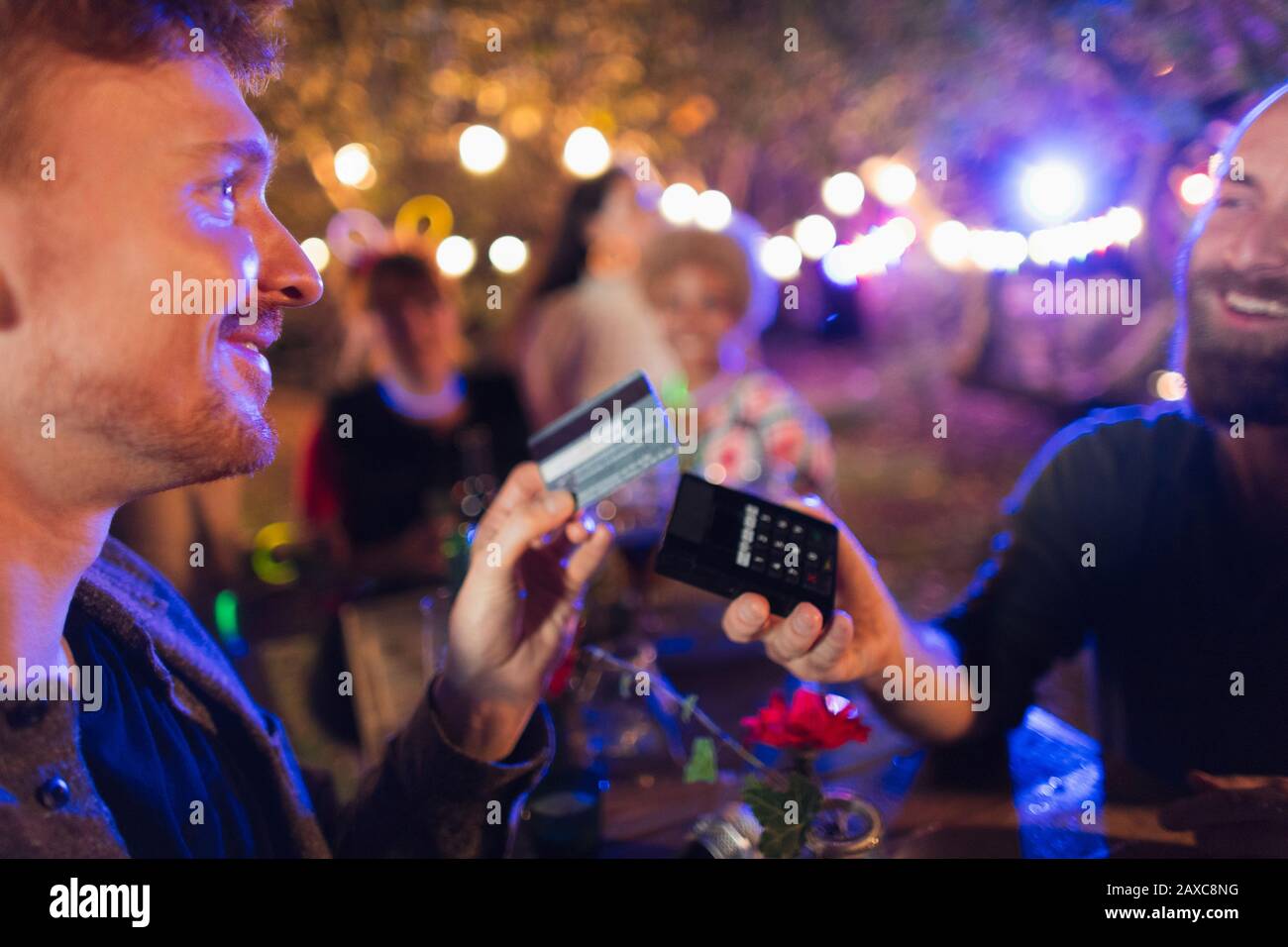 Homme avec carte de crédit payant barman à la fête Banque D'Images