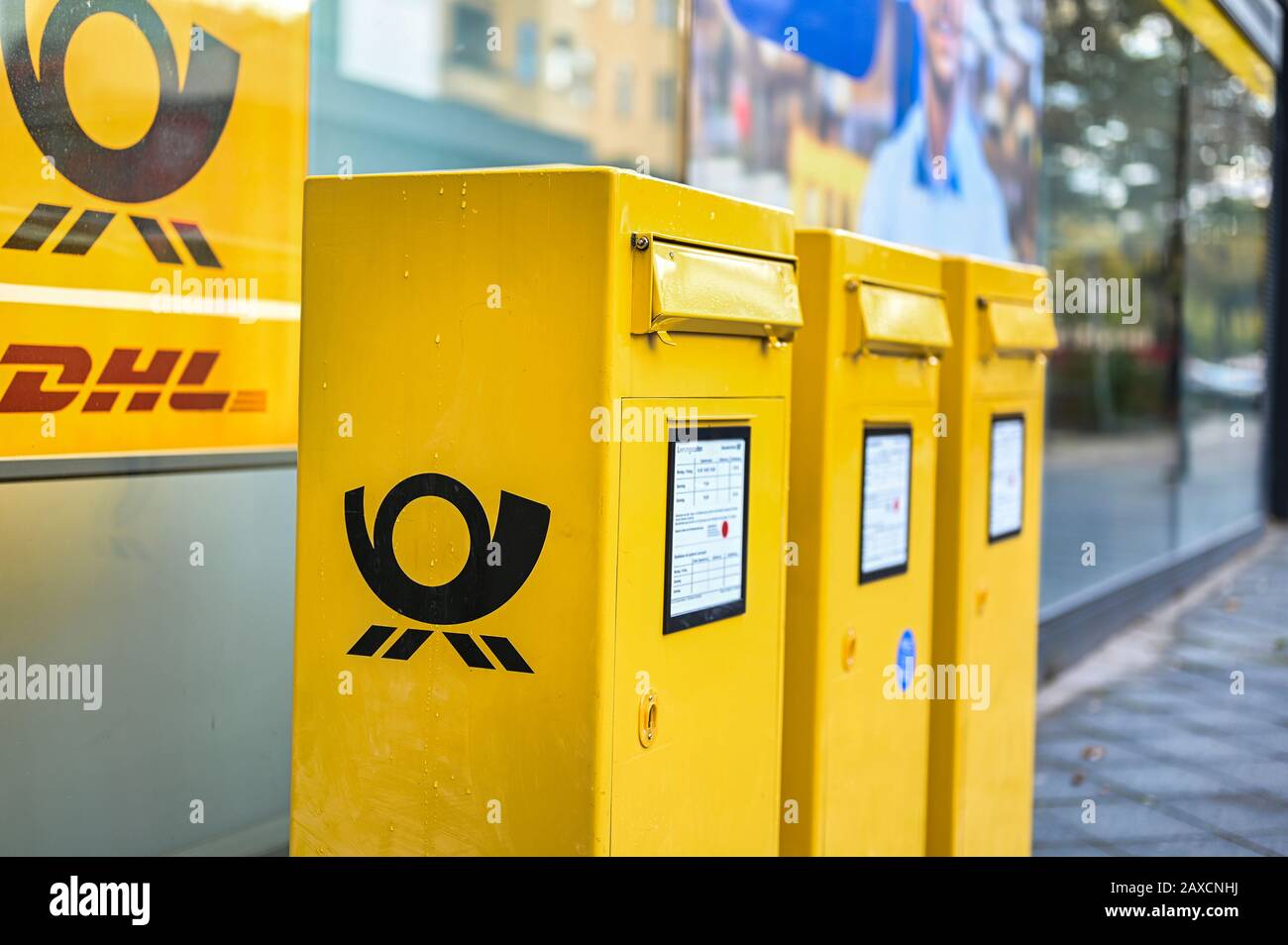 Berlin, Allemagne - 5 octobre 2019: Plusieurs boîtes aux lettres avec le logo du poste allemand en jaune typique sur un trottoir à Berlin, Allemagne. Banque D'Images