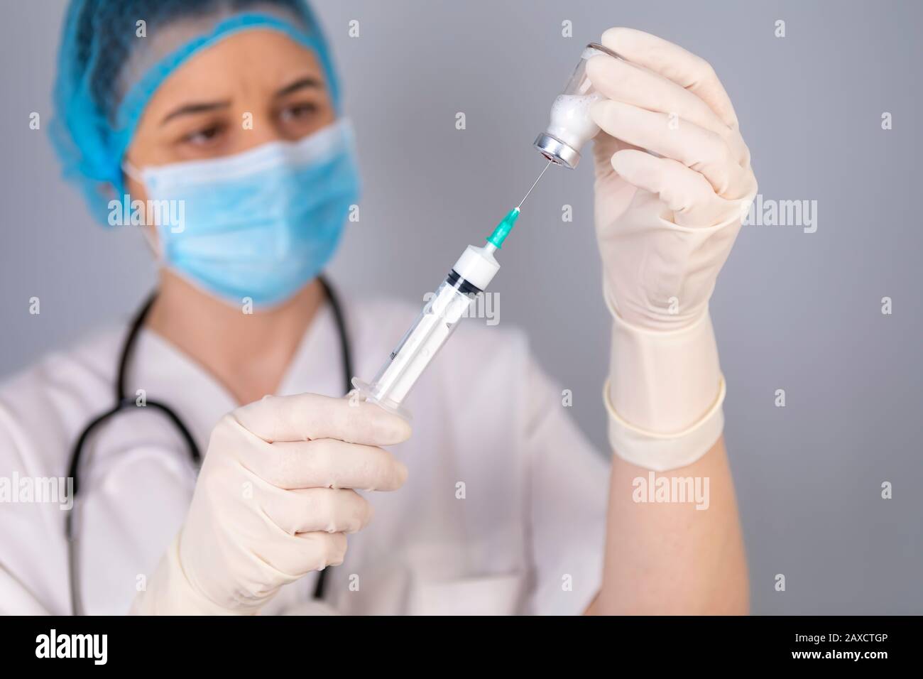 Mains du médecin remplissant la seringue de vaccin. Concept de traitement médical. La seringue est mise au point. Banque D'Images