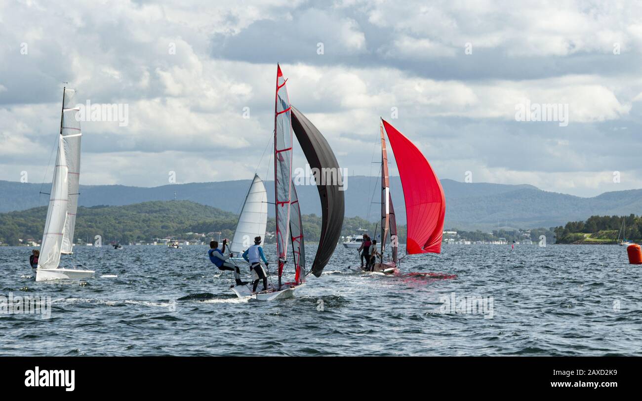 Les enfants naviguent dans de petits bateaux colorés et des dinghies pour s'amuser et en compétition. Travail d'équipe par des marins juniors en course sur le lac d'eau salée Macquarie. Phot Banque D'Images