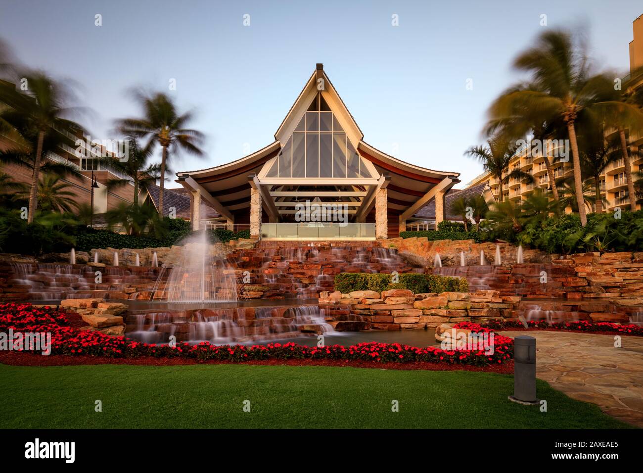 Hôtel et complexe de style Bali dans un cadre tropical avec palmiers et  fontaine à l'entrée Photo Stock - Alamy