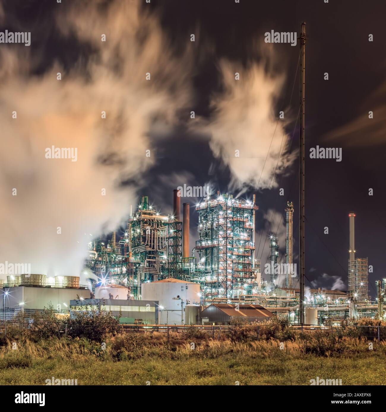 Scène de nuit avec vue sur la production pétrochimique plante avec des panaches de fumée, Port d'Anvers, Belgique. Banque D'Images