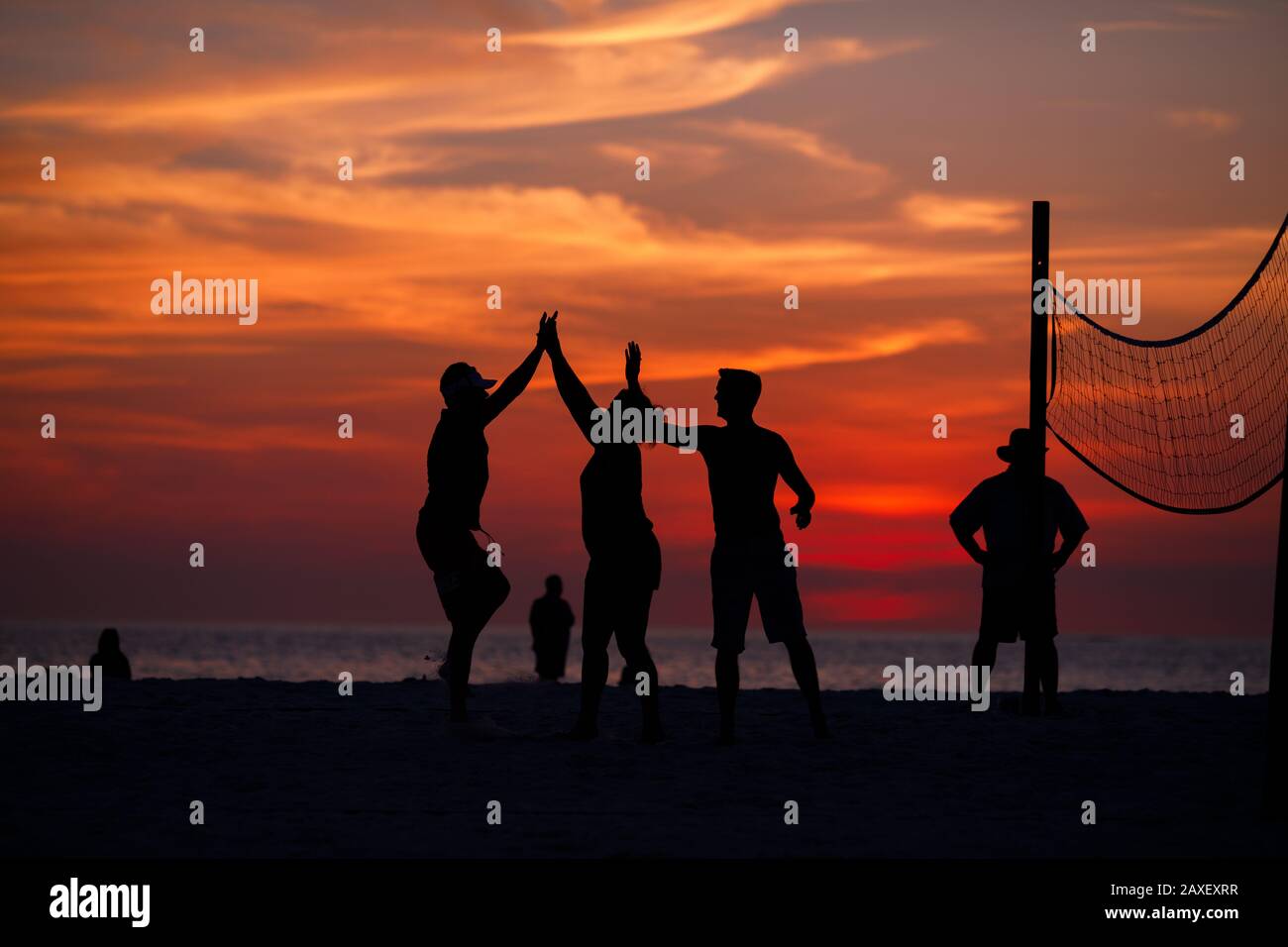 Les gens de Holliday jouent au volley-ball sur la plage au coucher du soleil Banque D'Images