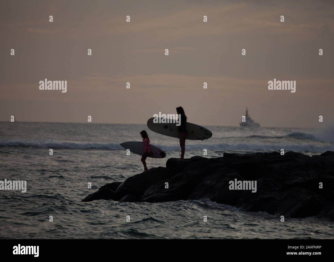 Surfeurs au coucher du soleil à Hawaï Banque D'Images
