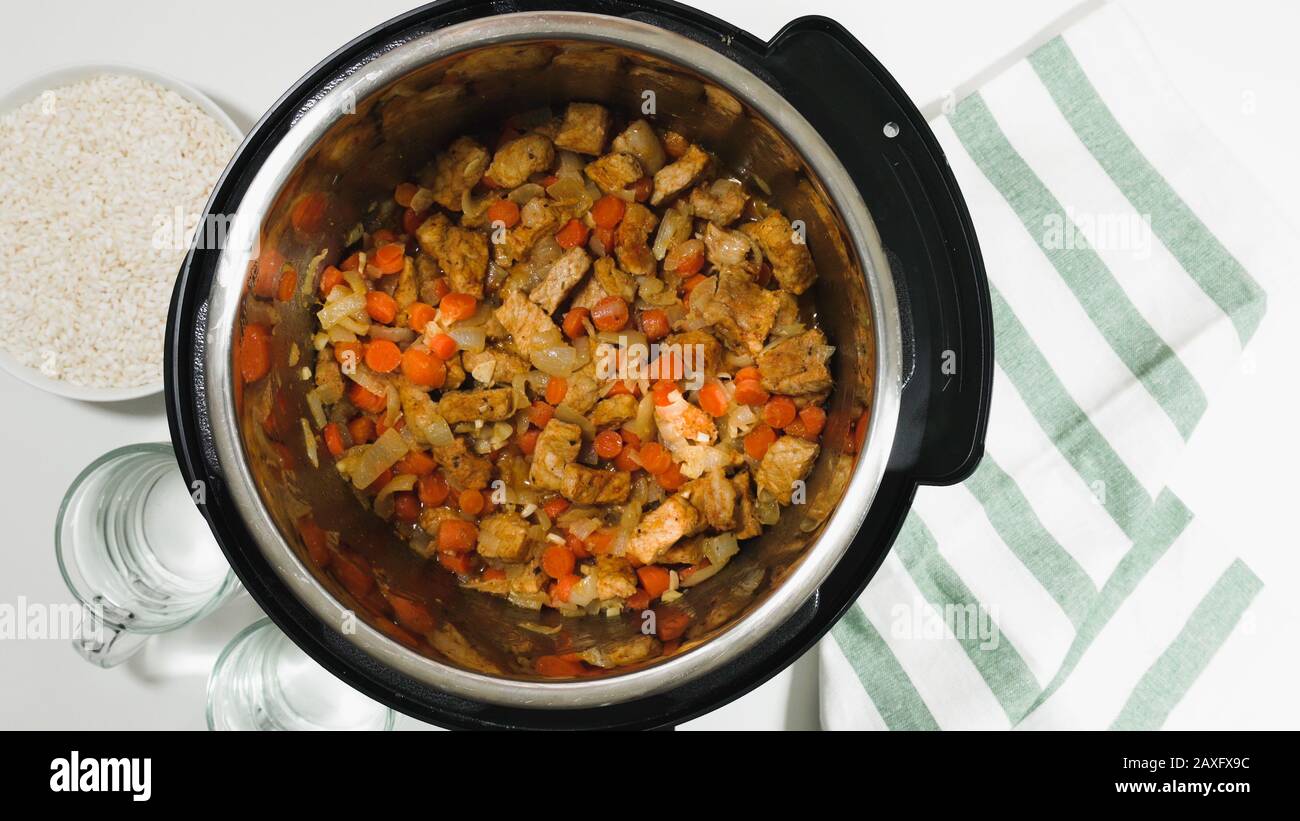 Cuisson du riz avec de la viande et des légumes dans un cuiseur multi-pression étape par étape, vue de dessus. Saute de viande et légumes marinés hachés. Banque D'Images