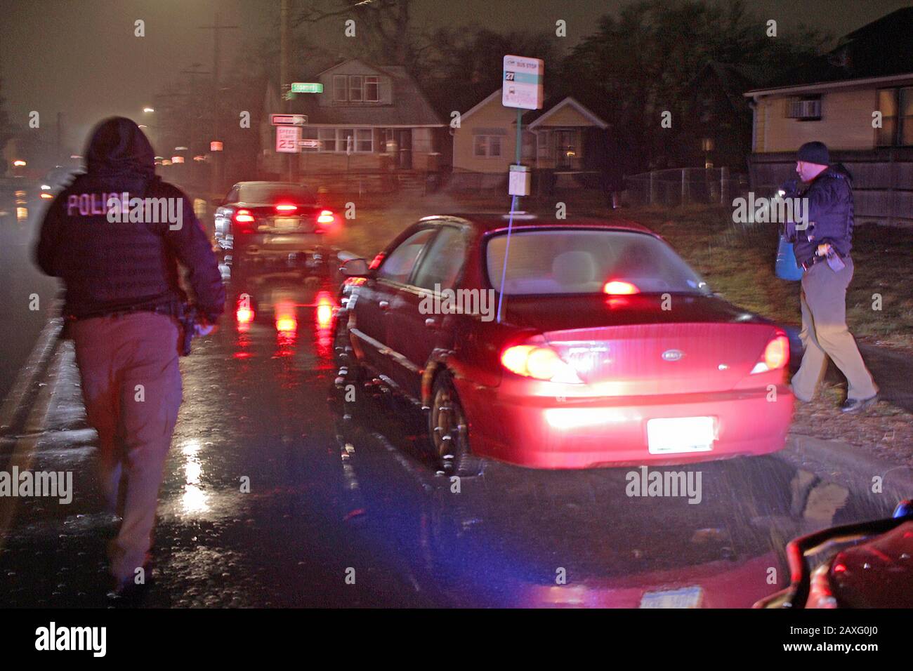 Les policiers de Detroit s'approchoch en véhicule lors d'un arrêt de circulation pendant une nuit de pluie à Detroit, Michigan, États-Unis Banque D'Images