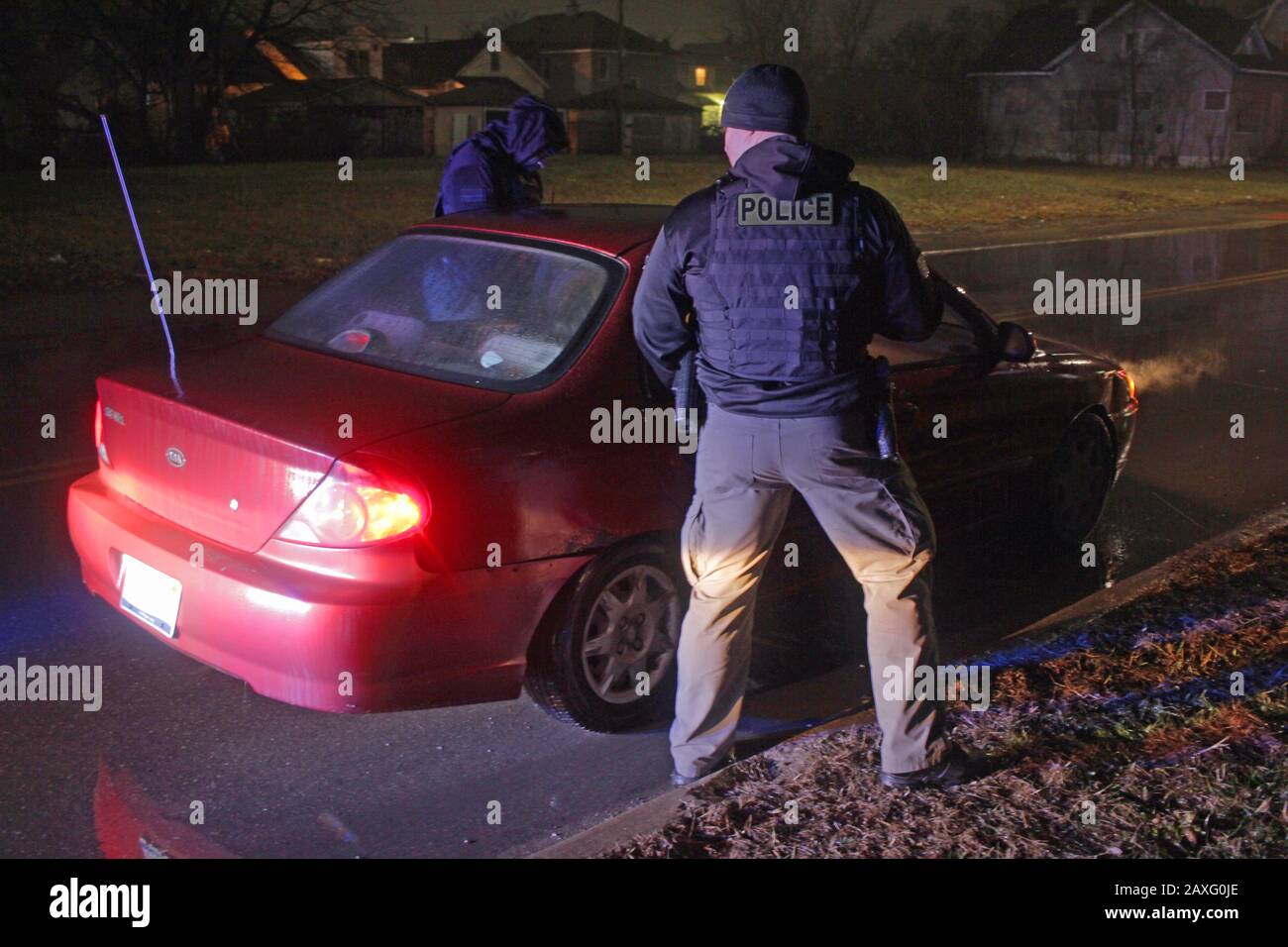 Les policiers de Detroit parlent au conducteur d'une voiture lors d'un arrêt de circulation pendant une nuit de pluie à Detroit, Michigan, États-Unis Banque D'Images