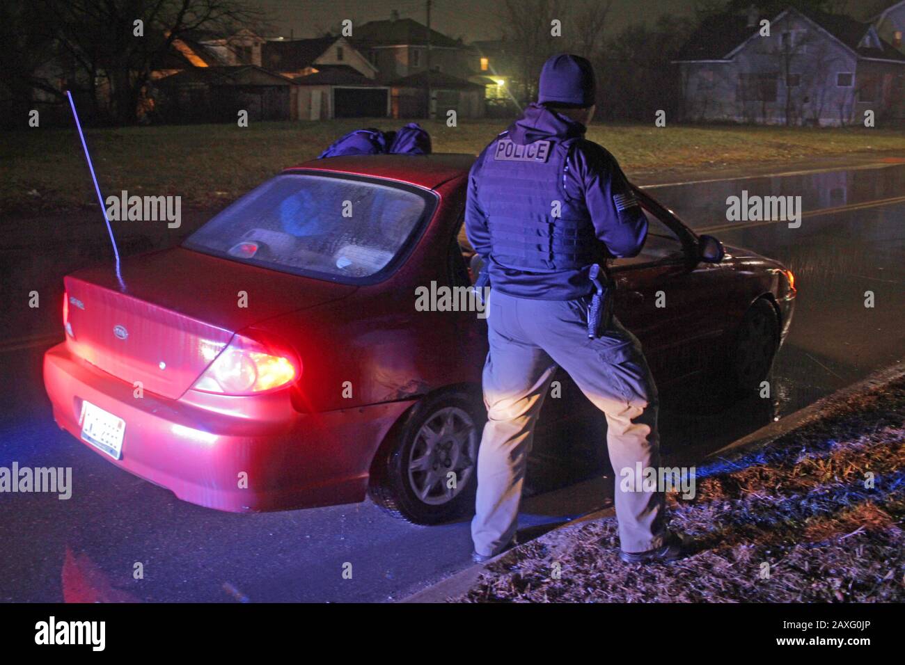 Les policiers de Detroit parlent au conducteur d'une voiture lors d'un arrêt de circulation pendant une nuit de pluie à Detroit, Michigan, États-Unis Banque D'Images