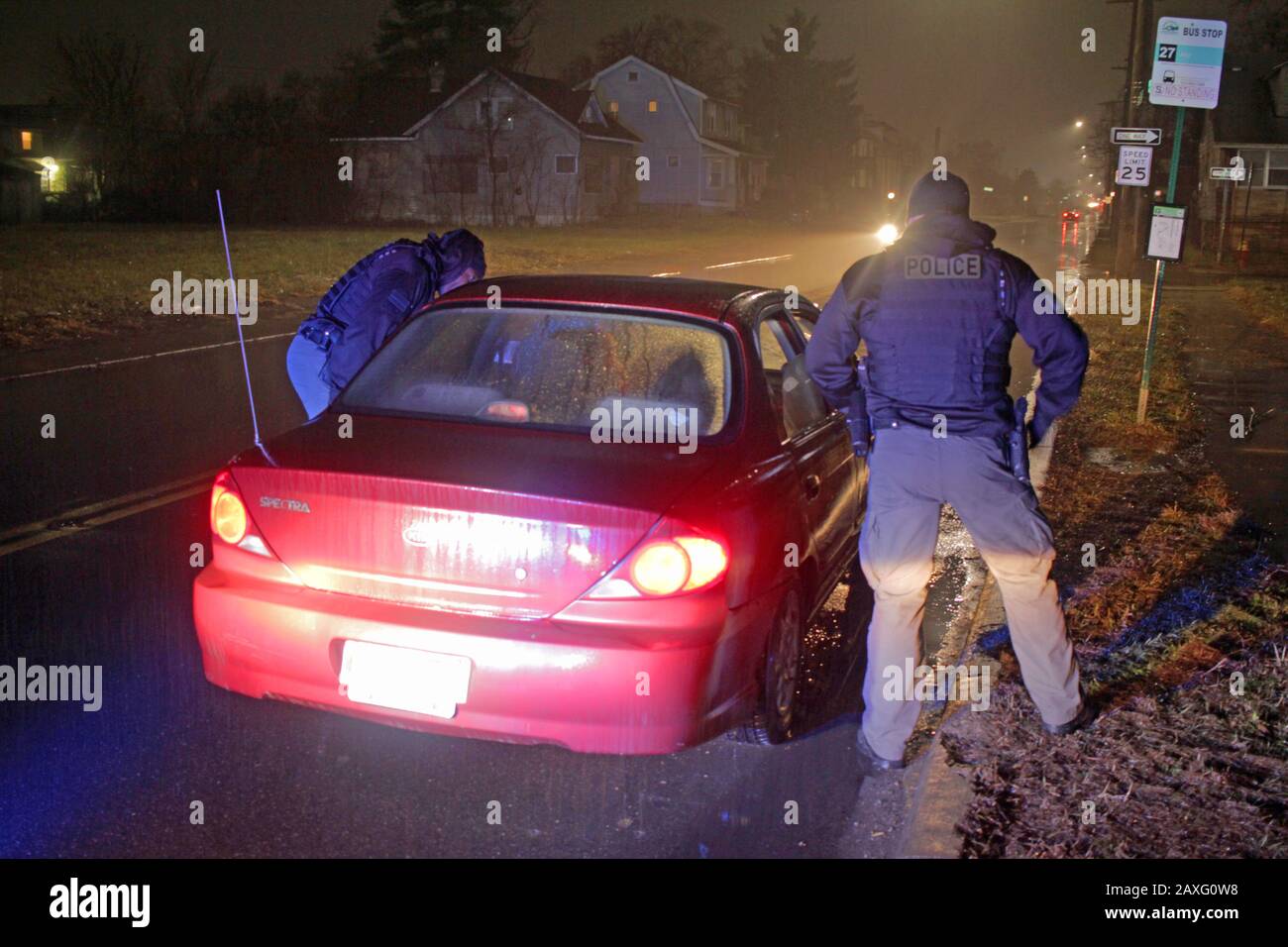 Les policiers de Detroit parlent au conducteur d'une voiture lors d'un arrêt de circulation pendant une nuit de pluie à Detroit, Michigan, États-Unis Banque D'Images
