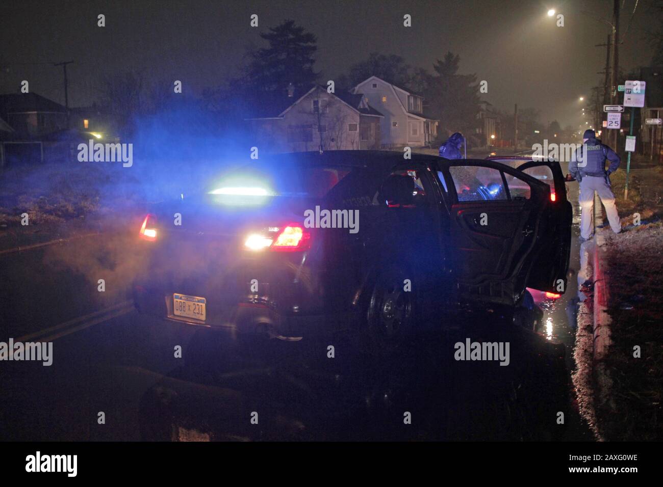Les policiers de Detroit parlent au conducteur d'une voiture lors d'un arrêt de circulation pendant une nuit de pluie à Detroit, Michigan, États-Unis Banque D'Images