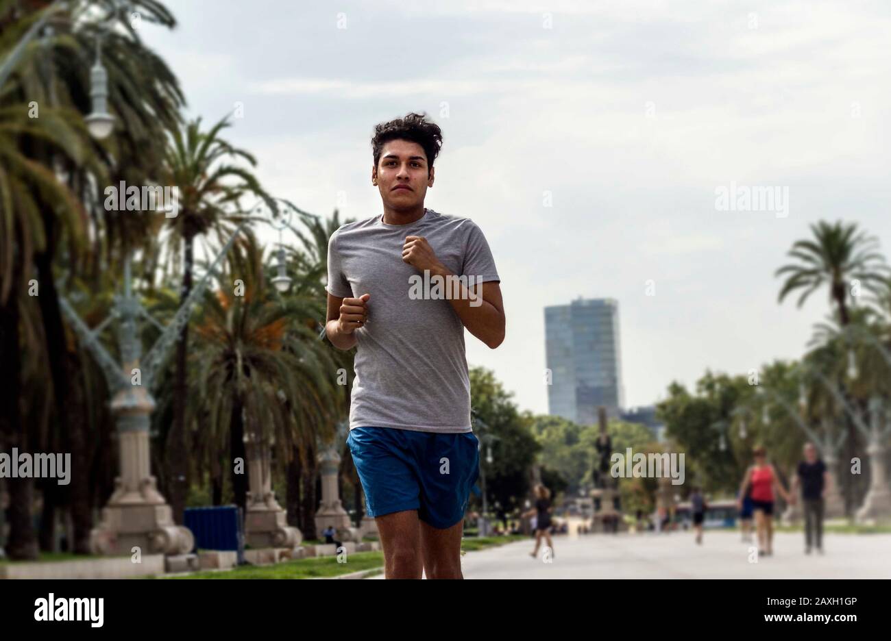 Jeune homme latin qui fait du jogging ou de la course dans un parc de la ville Banque D'Images