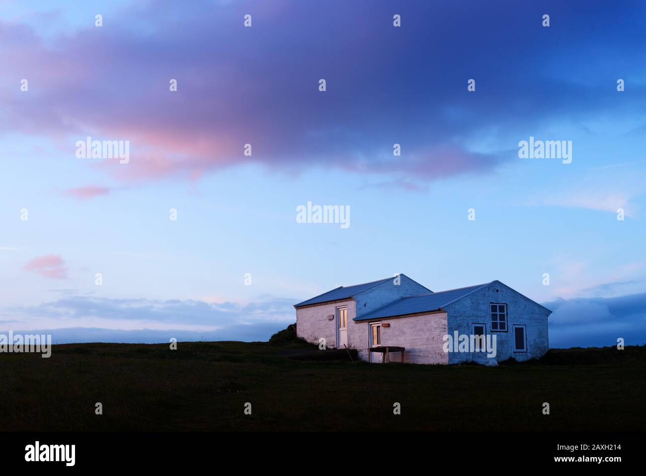 Petite maison de gardien de phare sur La Réserve naturelle de Dyrholaey, Islande, Europe. Photographie de paysage Banque D'Images