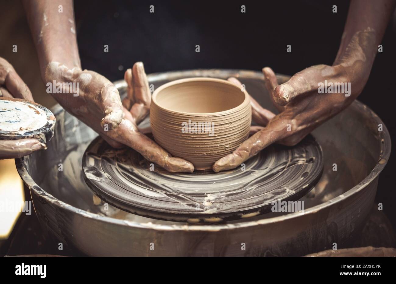 Un pot d'argile brute dans les mains d'un potter. Maître crock. Banque D'Images