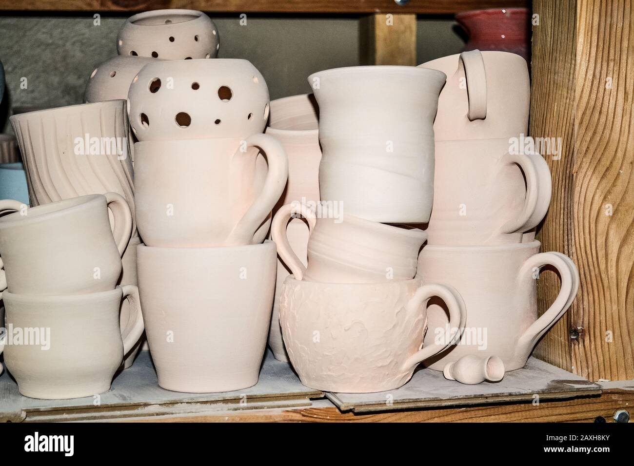 Poterie lumineuse. Beaucoup de poterie blanche, non peinte en argile se tenant sur des étagères en bois Banque D'Images