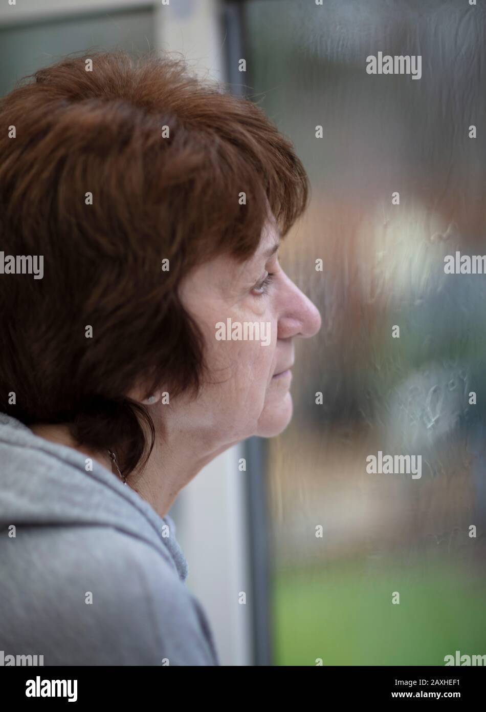 Lady regardant la forte pluie de sa fenêtre de maison Banque D'Images