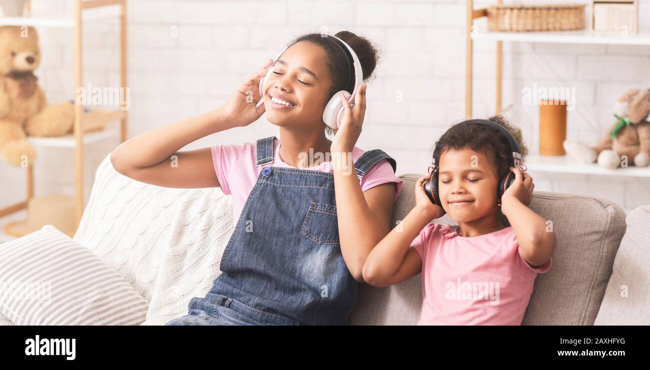 Sœurs africaines appréciant la musique préférée dans les écouteurs Banque D'Images