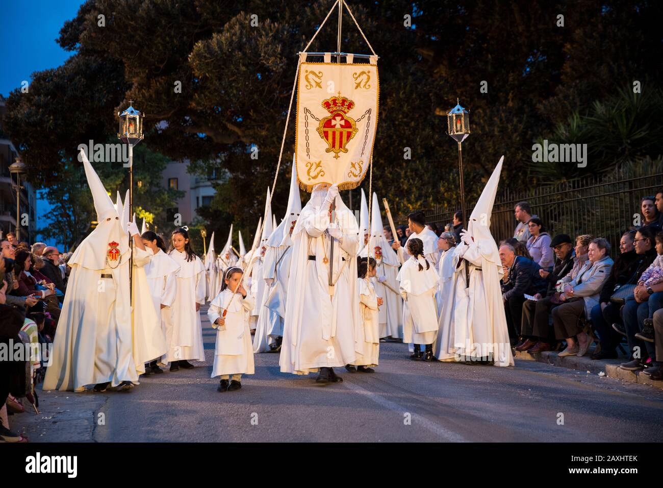 Saint-jeudi procession de pénitents de confrérie d'église dans des hottes coniques et des peignoirs de différentes couleurs portant des statues religieuses Banque D'Images