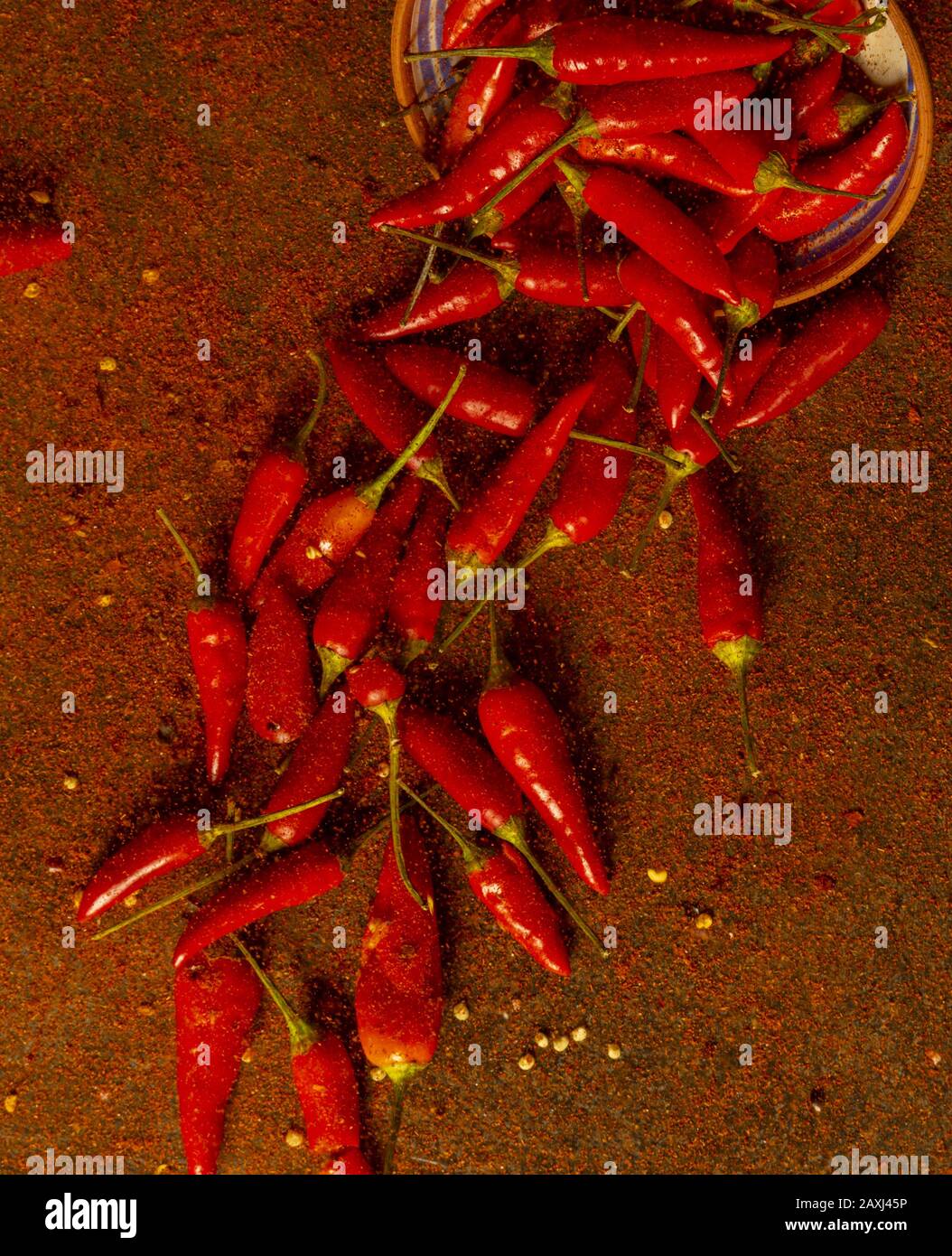 des piments frais d'un bol recouvert d'une couche plate de poudre de piment Banque D'Images