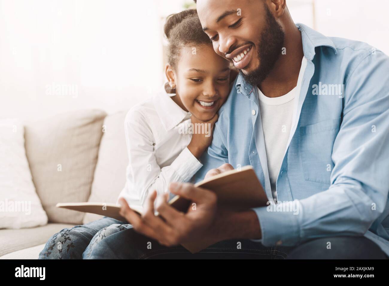 Un livre de lecture de papa affectueux à sa fille heureuse Banque D'Images