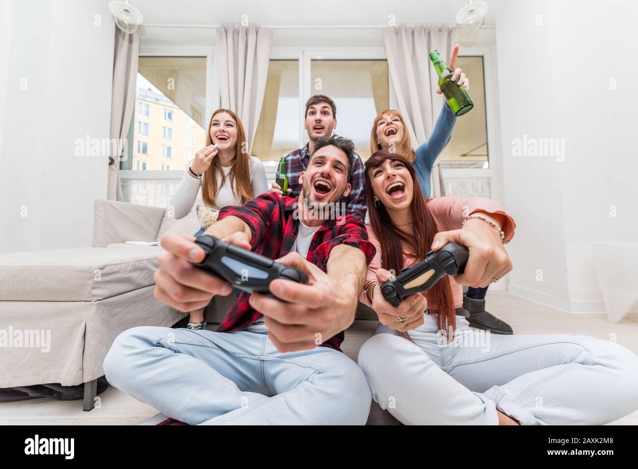 Amis jouant aux jeux vidéo s'amuser dans le salon. Concept de divertissement à domicile. Banque D'Images