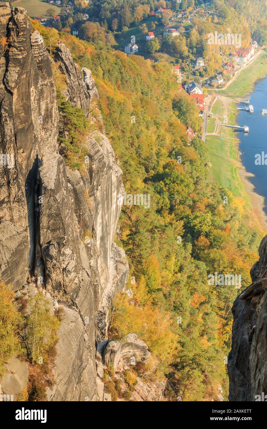 Vue depuis le pont Bastei, dans les montagnes de la pierre de sable d'Elbe. Formation de roches, soleil, arbres et maisons avec la vallée de l'Elbe. Banque D'Images