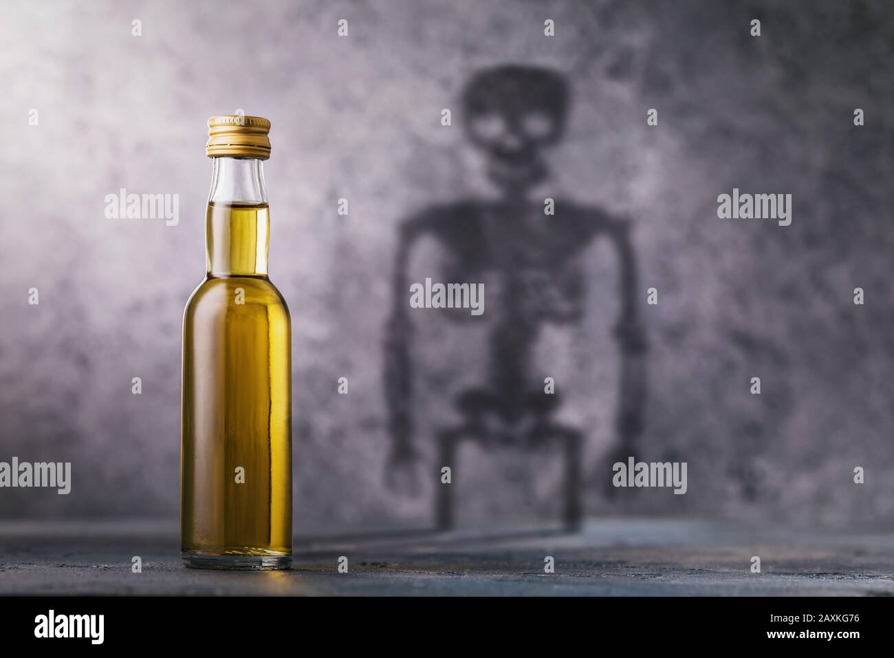 Une bouteille de whisky avec une ombre en forme de squelette. Concept sur le préjudice de l'alcool et les habitudes nocives de l'homme Banque D'Images
