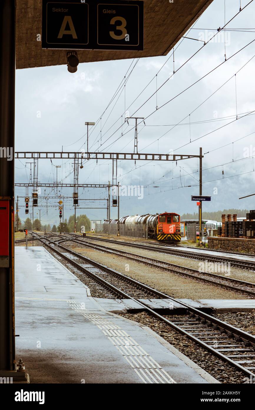 Pontresina, Grisons, Suisse - 9 août 2016 : locomotive à shunt orange du chemin de fer Raethian (RHB) devant les wagons-citernes sur une voie latérale dans le TH Banque D'Images