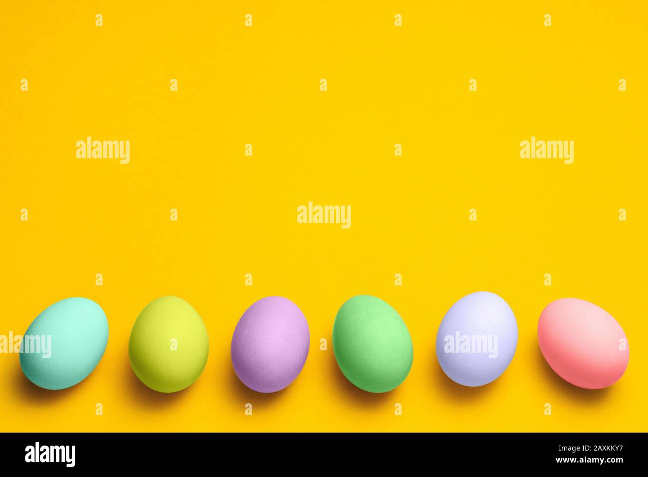 les œufs de pâques peints dans des tons pastel sur un fond jaune avec un espace publicitaire. pâques annoncer design minimaliste concept Banque D'Images