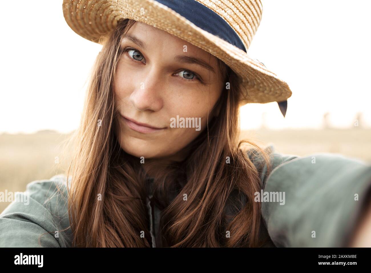 la jeune femme sourit à l'appareil photo et prend un selfie Banque D'Images