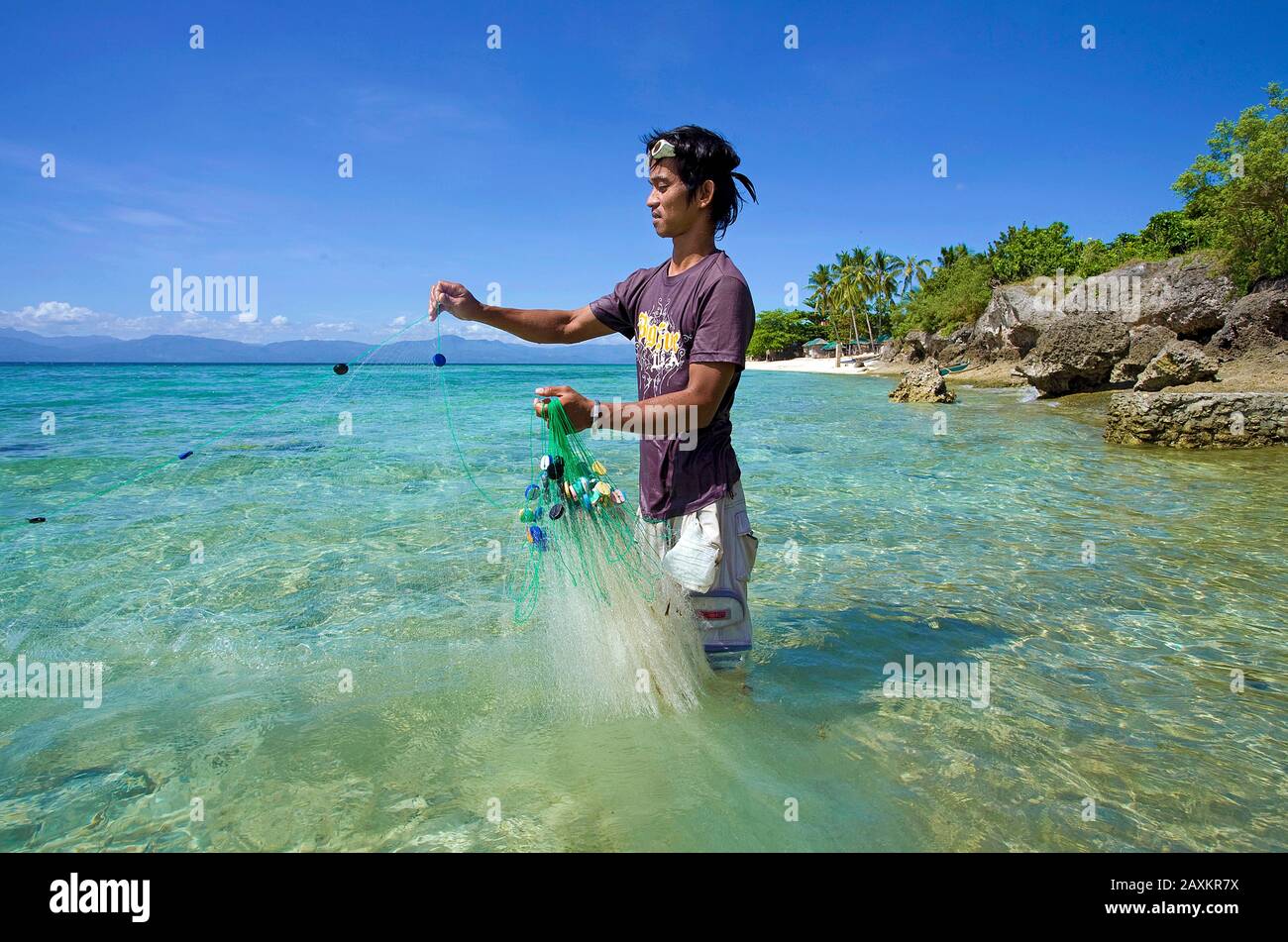 Pêche aux pêcheurs avec poissons-appâts à filet de poisson dans le lagon, la plage blanche, Moalboal, Cebu, Philippines Banque D'Images
