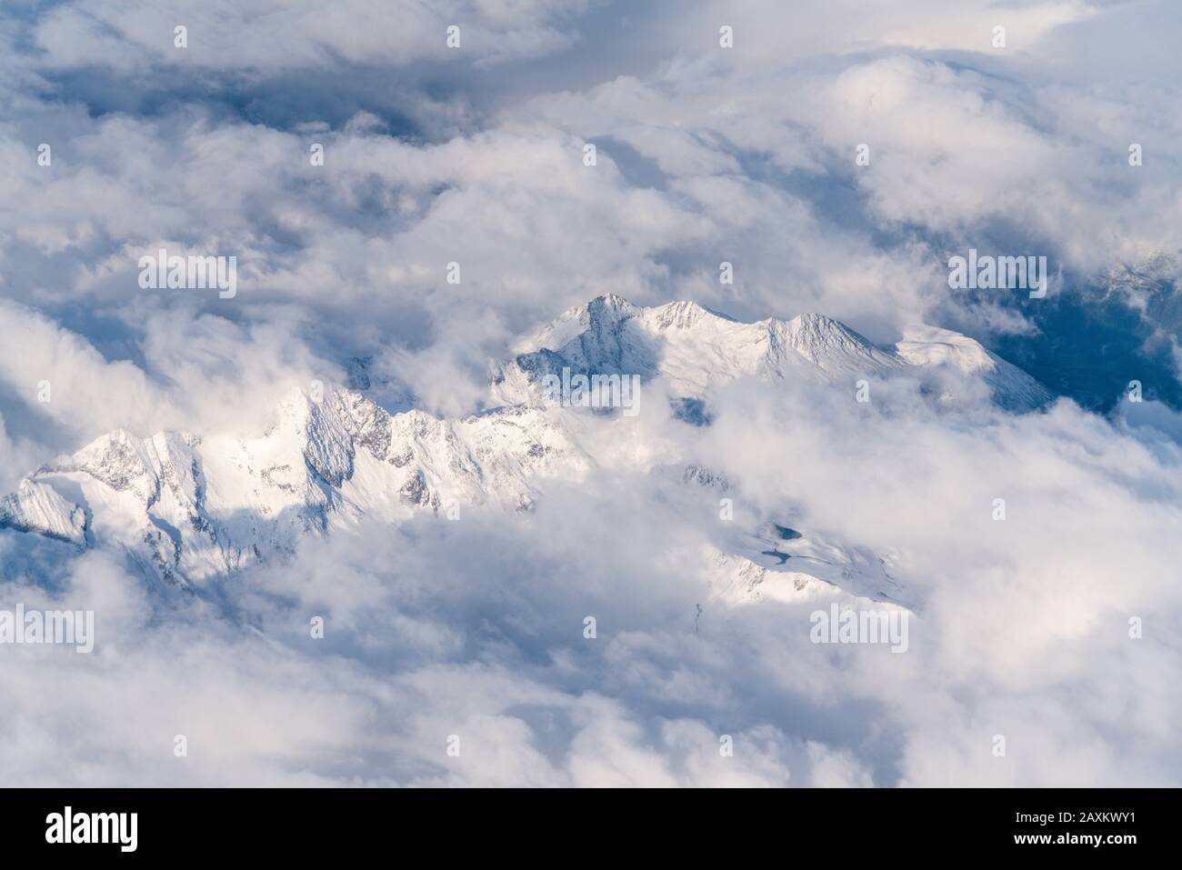 Survolant les Alpes italiennes et suisses recouvertes de neige dans une mer de nuages, en Italie Banque D'Images