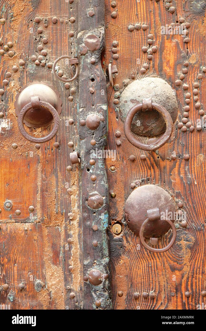 Détails d'une porte en bois ornée à l'intérieur de la médina de Tozeur, Tunisie, avec des knockers traditionnels Banque D'Images