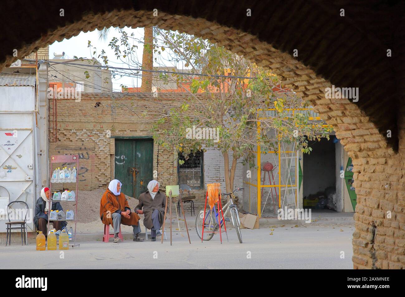 Tozeur, TUNISIE - 21 DÉCEMBRE 2019: Les habitants traditionnellement vêtus de la médina à travers une arcade Banque D'Images