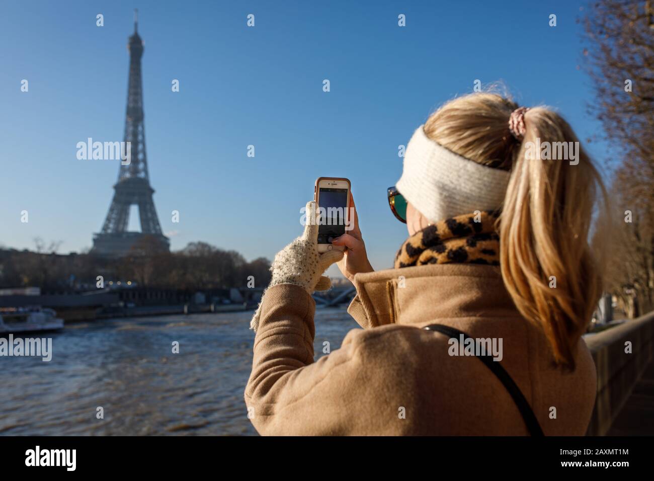 Un jeune adulte prend une photo iPhone de la Tour Eiffel à Paris. Banque D'Images