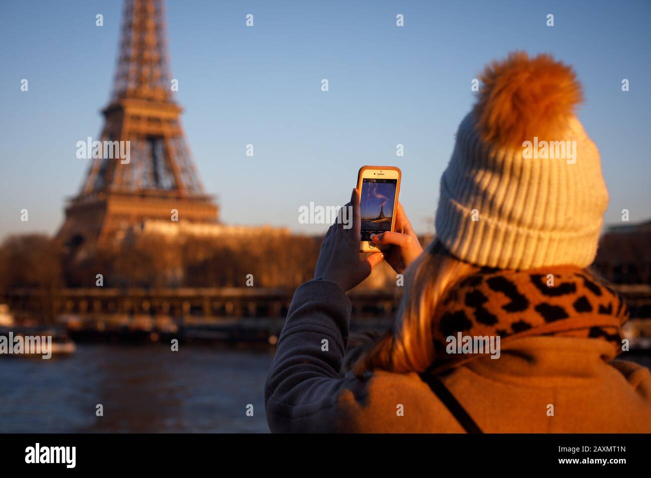 Un jeune adulte prend une photo iPhone de la Tour Eiffel à Paris. Banque D'Images