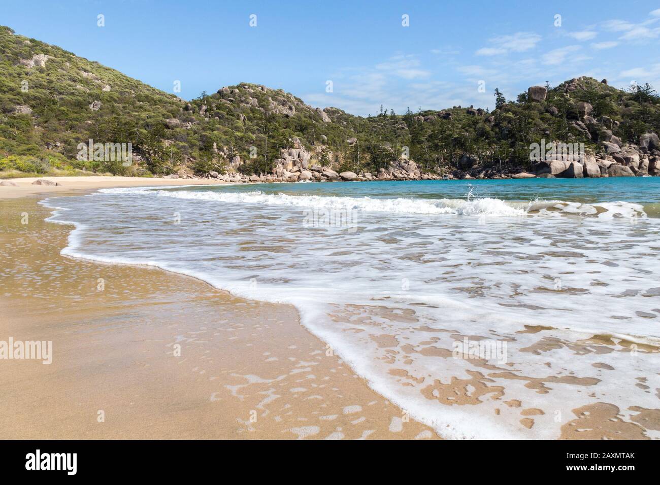 Petites vagues se brisant sur la plage de sable clair de l'île magnétique Banque D'Images