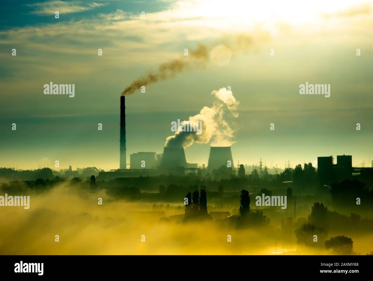 usine avec des tuyaux et de la fumée à l'aube du coucher du soleil. Paysage urbain rouge et orange. Paysage avec fumée et brouillard du matin. Contraste avec la silhouette sombre de la plante Banque D'Images