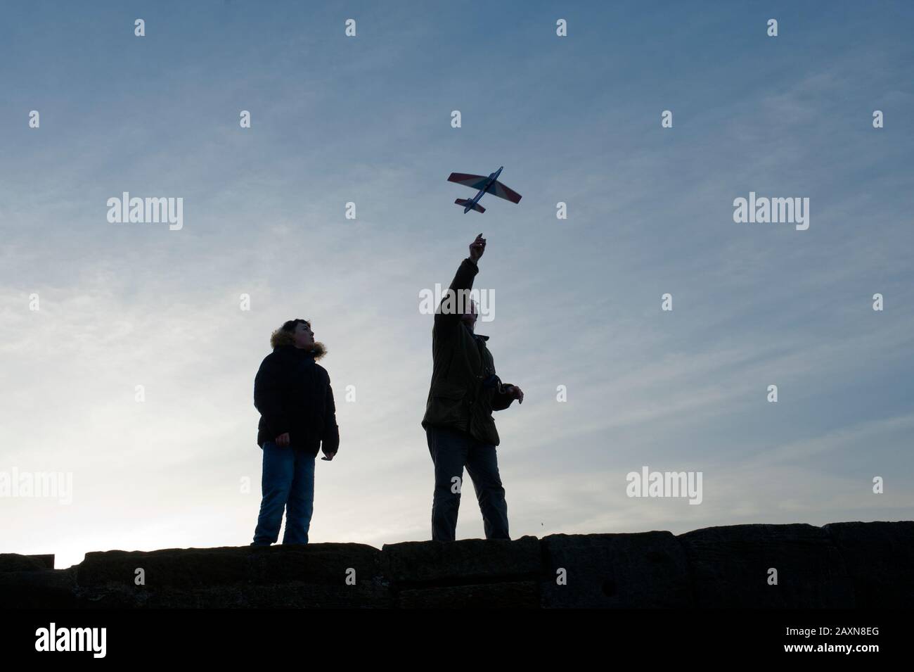 Grand-père de 82 ans et grand-mère de 84 ans et petit-fils adolescents volant des avions en papier ensemble au large de la jetée de Tate Hill à Whitby, dans le North Yorkshire, au Royaume-Uni. Banque D'Images