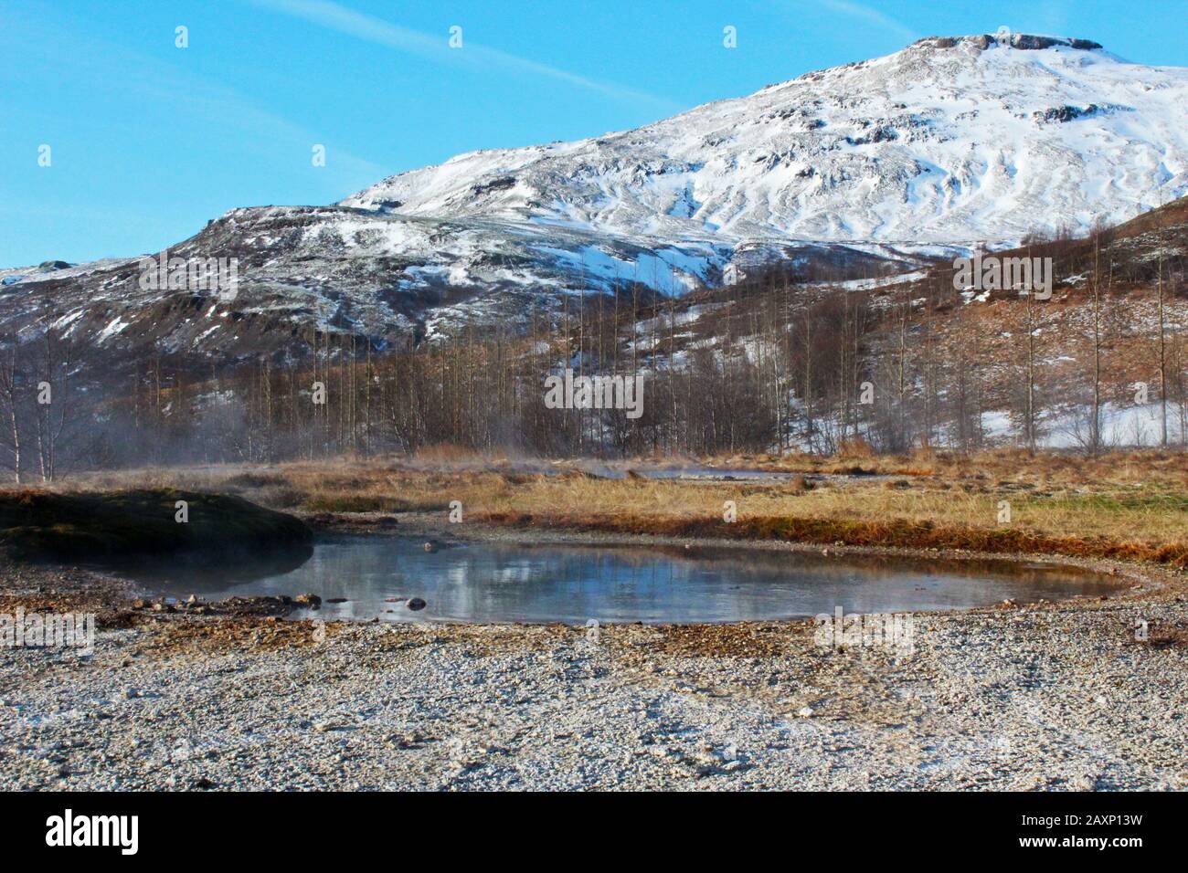 Superbe montagne enneigée et source chaude dans le parc Geysir, Islande, une journée lumineuse Banque D'Images