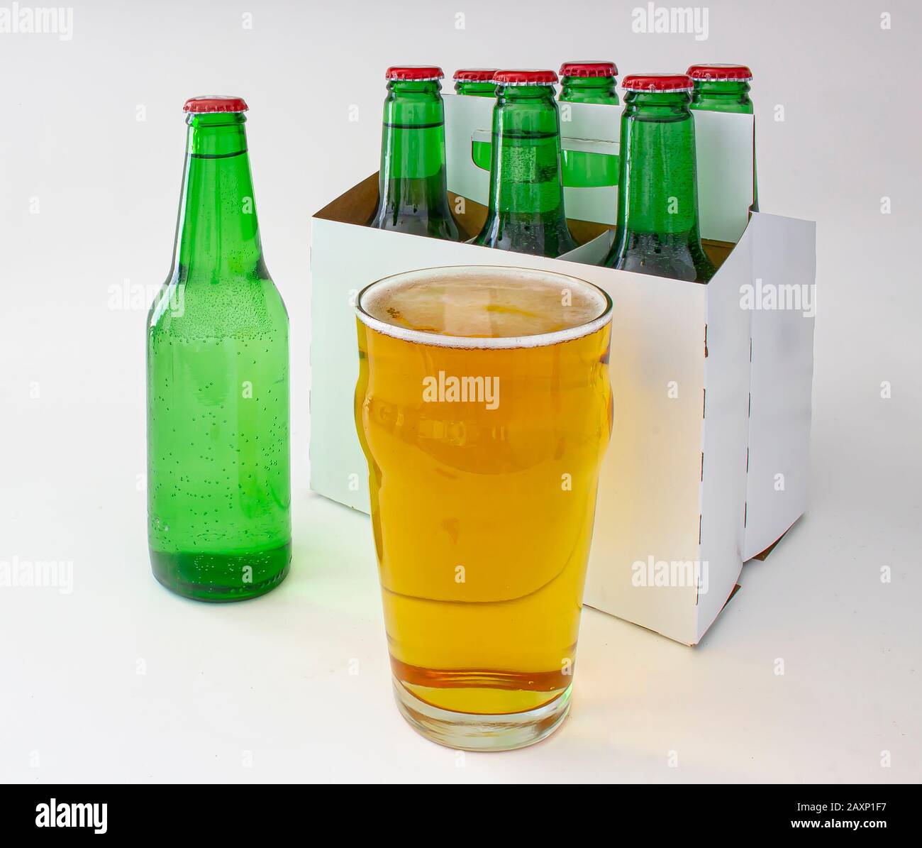 Un paquet de six bouteilles de bière pilsner avec une pinte complète de bière Banque D'Images